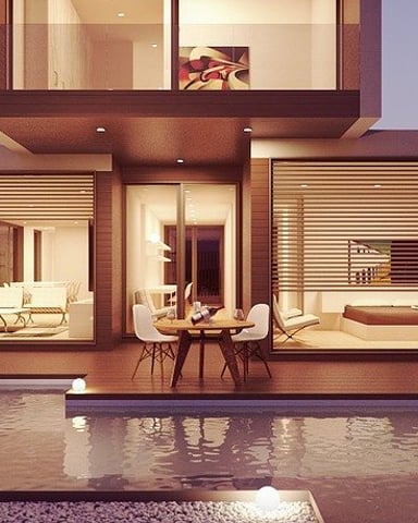 Modern house with illuminated interior, infinity pool, and lounge chairs at dusk with purple sky