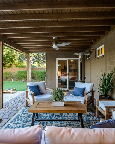 Covered patio with wooden furniture, ceiling fan, and view of pool and landscaped backyard